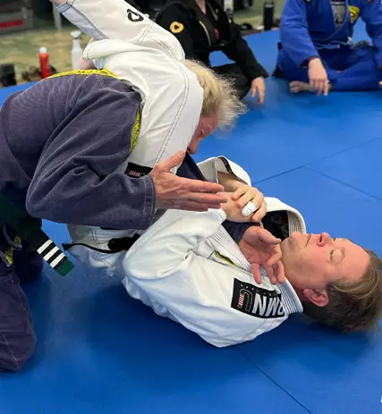 Adults practicing jiu jitsu techniques during a class at Frequency Martial Arts in Bloomington, Illinois.